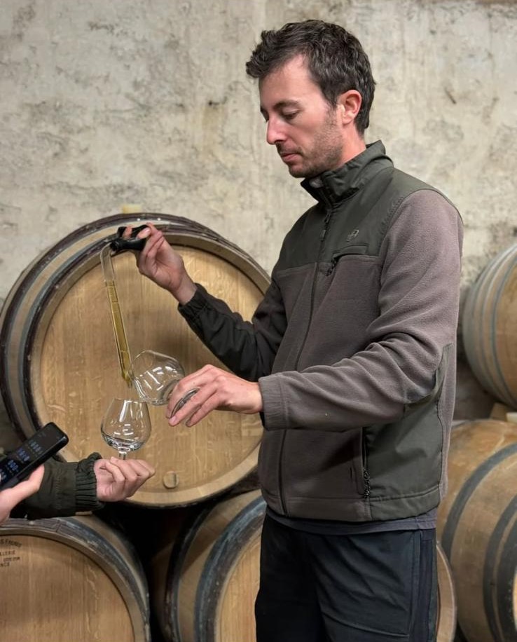 Guilbert Gillet nella sua cantina mentre esegue la mescita del vino.